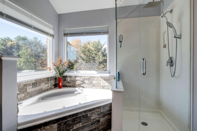 full bath featuring a wealth of natural light, a shower stall, and a whirlpool tub