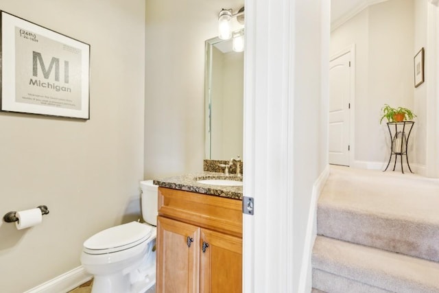 bathroom featuring toilet, baseboards, and vanity