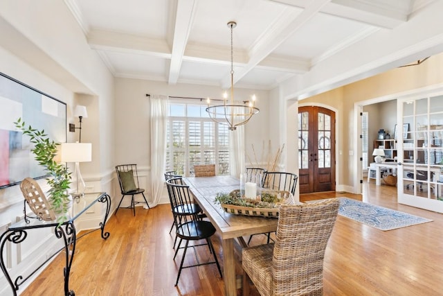 dining space featuring french doors, beam ceiling, a notable chandelier, light wood-style floors, and coffered ceiling