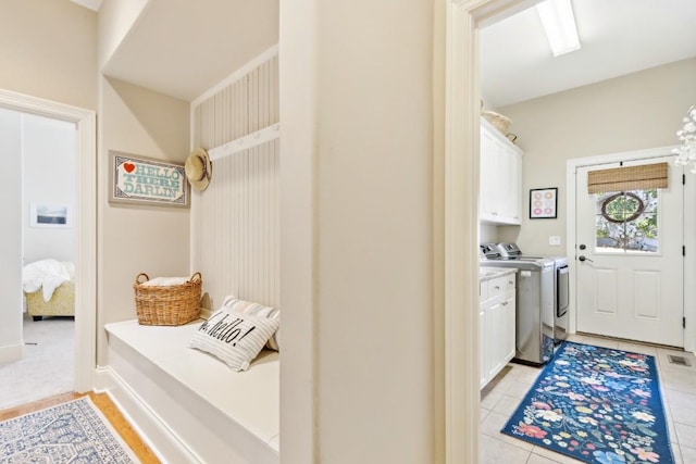 mudroom with washer and clothes dryer and light tile patterned floors