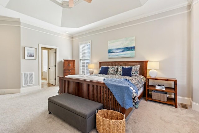 bedroom featuring light carpet, baseboards, visible vents, ornamental molding, and a tray ceiling