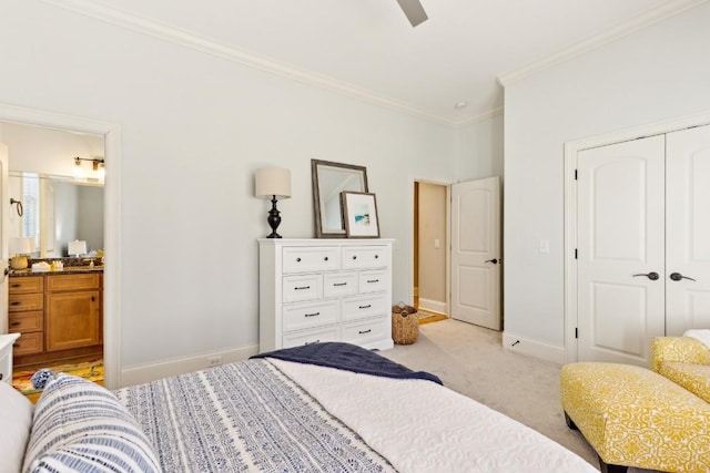 bedroom with connected bathroom, light carpet, baseboards, ornamental molding, and a closet