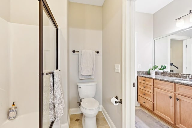 bathroom featuring toilet, vanity, a shower stall, baseboards, and tile patterned floors