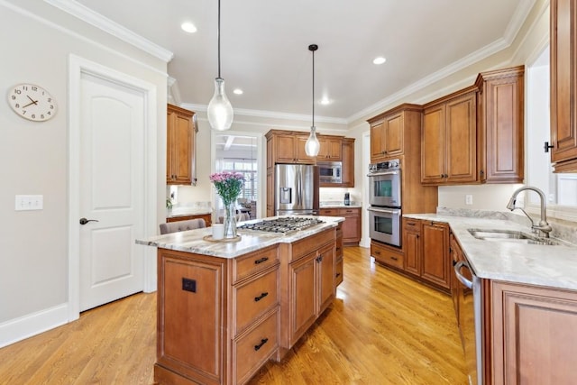 kitchen with brown cabinets, stainless steel appliances, a sink, a kitchen island, and light wood-type flooring