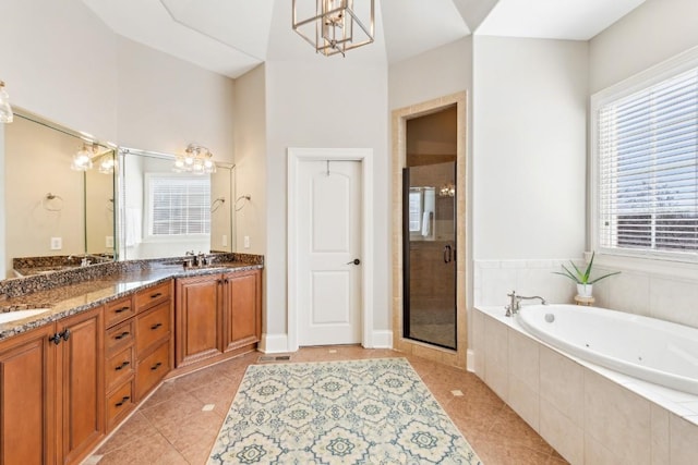 bathroom featuring a shower stall, an inviting chandelier, a garden tub, and tile patterned floors