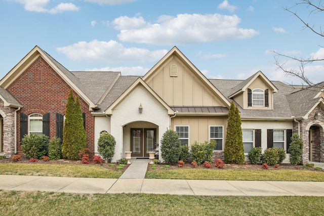 view of front of house with french doors, brick siding, board and batten siding, stone siding, and a front lawn