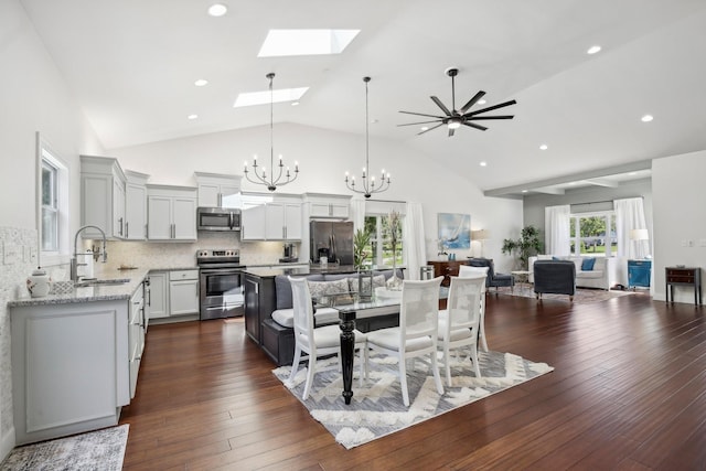 dining room featuring a skylight, high vaulted ceiling, dark wood-style flooring, and recessed lighting