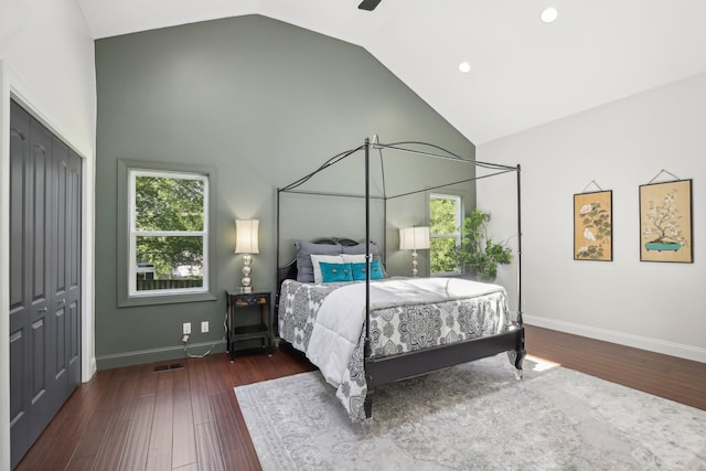 bedroom with high vaulted ceiling, a closet, baseboards, and wood finished floors