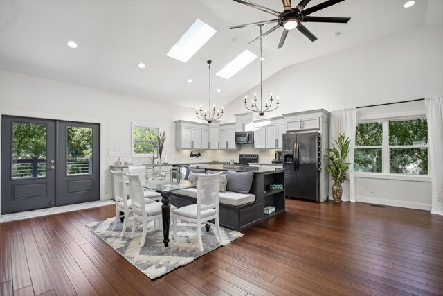 dining space featuring dark wood-style floors, a skylight, french doors, visible vents, and high vaulted ceiling