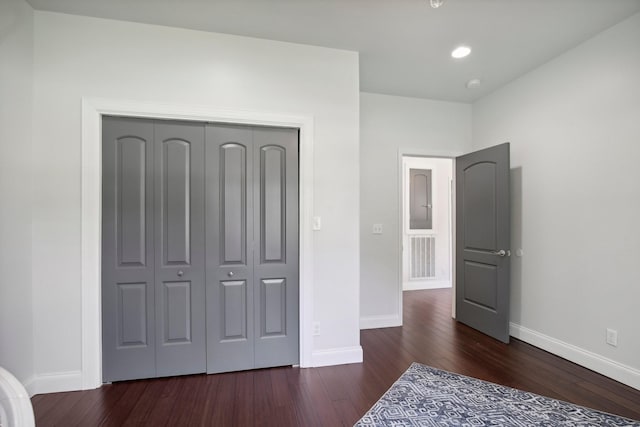 unfurnished bedroom with dark wood-style flooring, recessed lighting, a closet, and baseboards