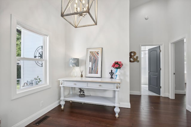 foyer entrance featuring visible vents, baseboards, and wood finished floors