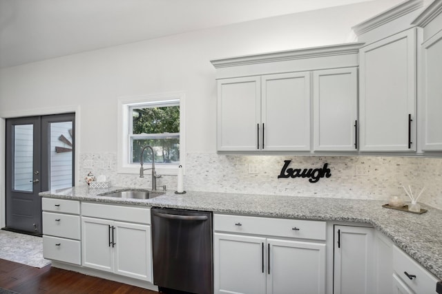 kitchen with light stone counters, dark wood-style flooring, backsplash, a sink, and dishwasher