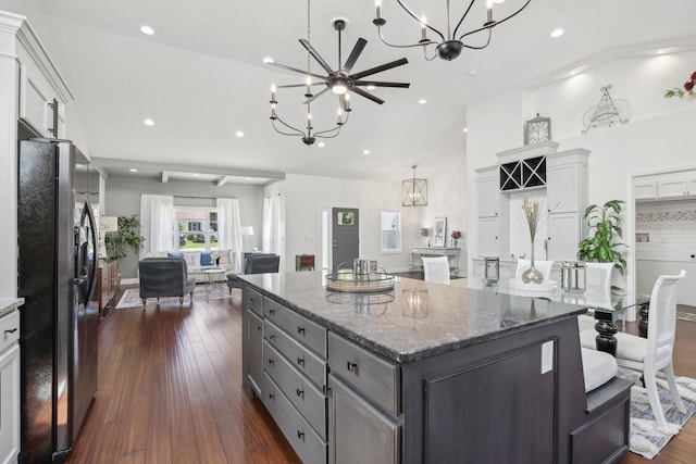 kitchen featuring stainless steel fridge, a kitchen island, vaulted ceiling, gray cabinetry, and a chandelier