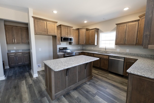 kitchen with stainless steel appliances, a kitchen island, a sink, and recessed lighting