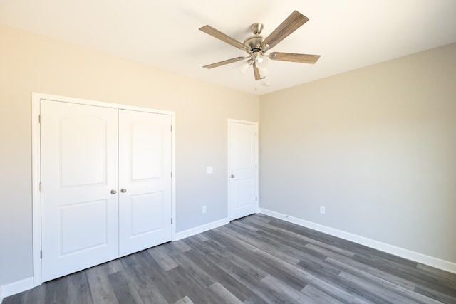 unfurnished bedroom with a closet, dark wood-style flooring, baseboards, and a ceiling fan