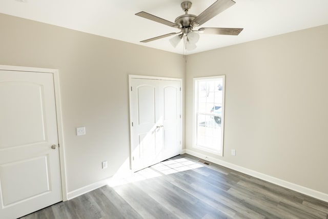 unfurnished bedroom featuring ceiling fan, baseboards, and wood finished floors