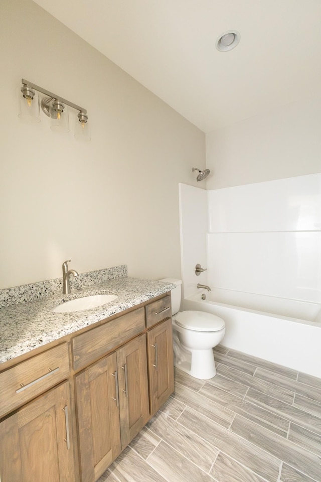 full bath with wood finish floors, shower / bath combination, vanity, and toilet