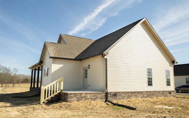 view of property exterior featuring a shingled roof and crawl space