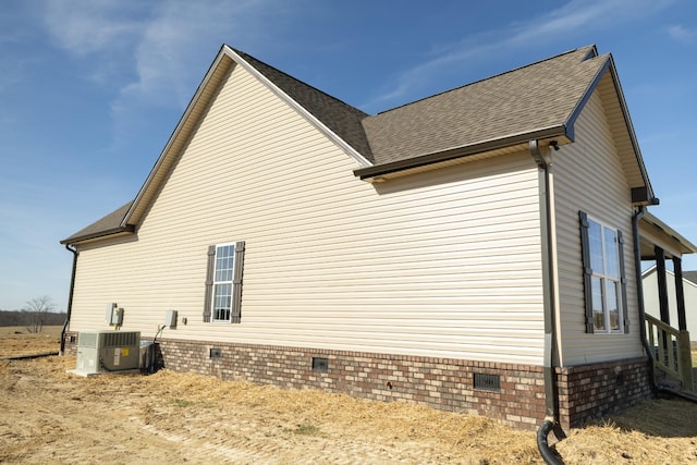 view of home's exterior featuring roof with shingles, crawl space, and cooling unit