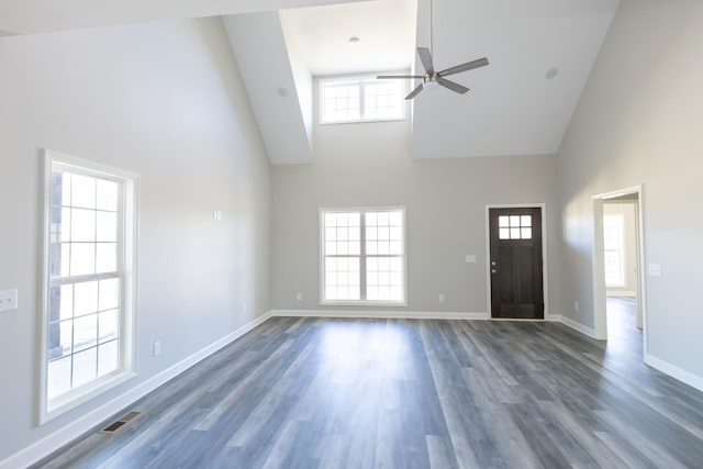 foyer featuring dark wood-style floors, visible vents, a high ceiling, ceiling fan, and baseboards