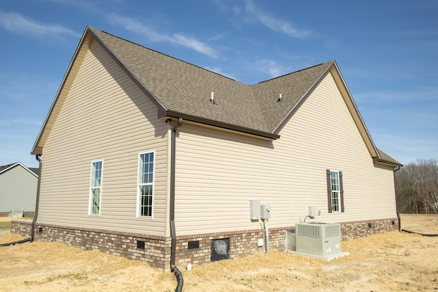 view of home's exterior featuring crawl space, central air condition unit, and roof with shingles