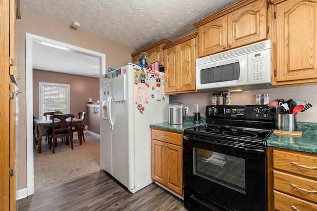 kitchen with dark wood-style floors, dark countertops, brown cabinetry, white appliances, and baseboards