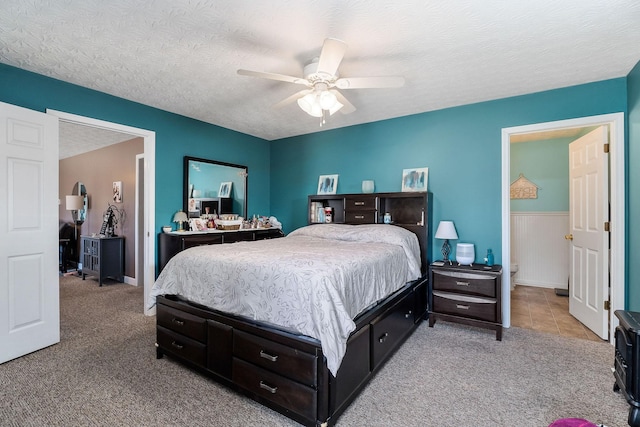 carpeted bedroom with a ceiling fan and a textured ceiling