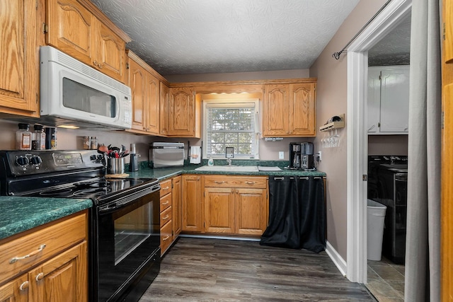 kitchen with dark countertops, white microwave, electric range, and a sink