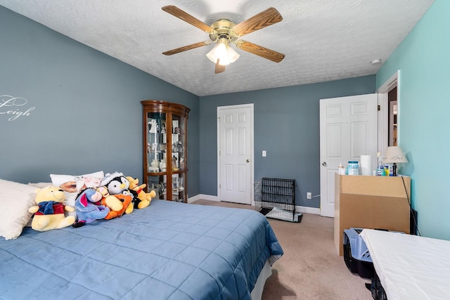 carpeted bedroom featuring ceiling fan, baseboards, and a textured ceiling