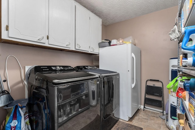 washroom with cabinet space, washing machine and dryer, a textured ceiling, and light tile patterned flooring