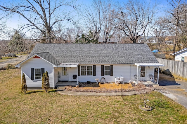 single story home with aphalt driveway, roof with shingles, a porch, a front yard, and fence