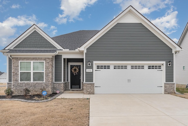 craftsman-style home featuring a garage, stone siding, driveway, and a shingled roof