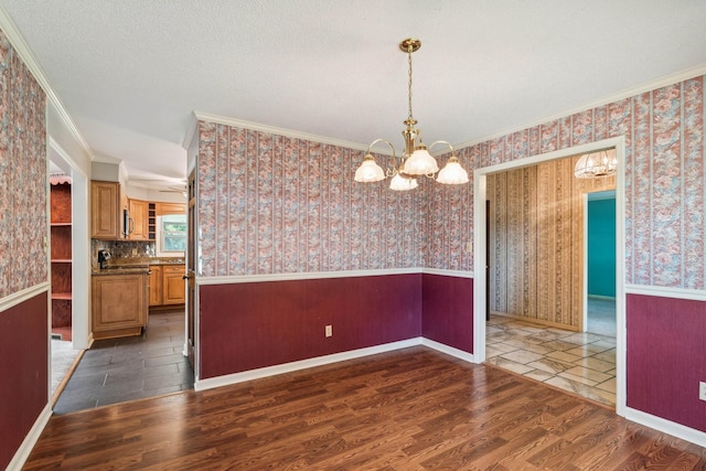 unfurnished dining area featuring wainscoting, wood finished floors, and wallpapered walls