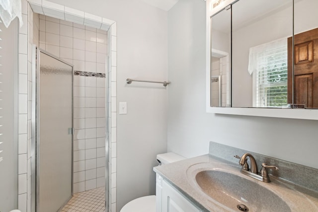 bathroom with vanity, a shower stall, and toilet