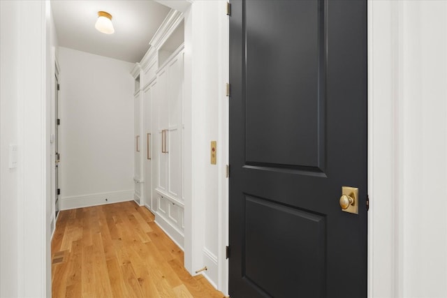 hallway with light wood-style floors and baseboards