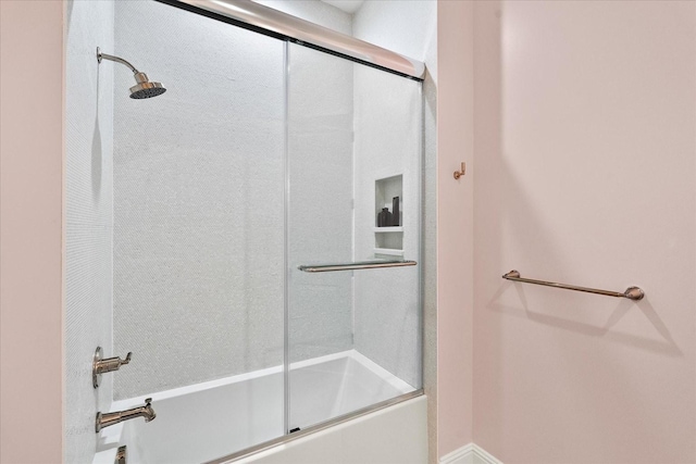 bathroom featuring bath / shower combo with glass door