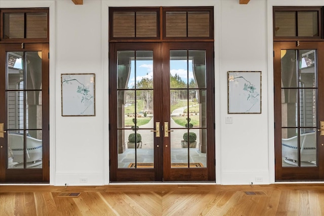 entryway featuring french doors, baseboards, and wood finished floors