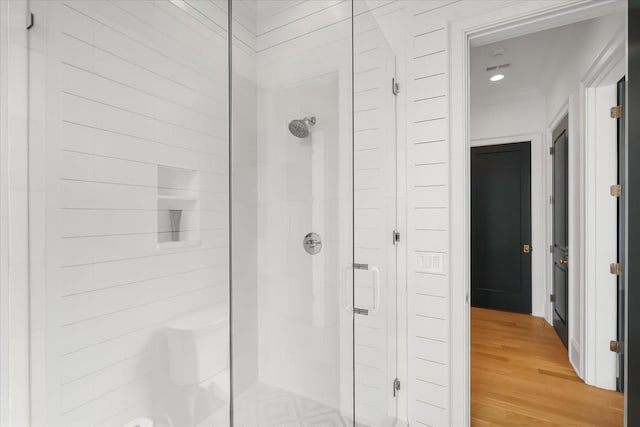 bathroom with a stall shower and wood finished floors