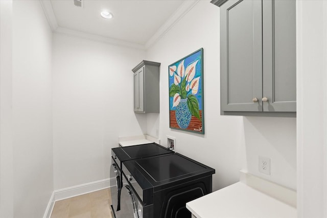 washroom with cabinet space, washing machine and dryer, ornamental molding, and baseboards