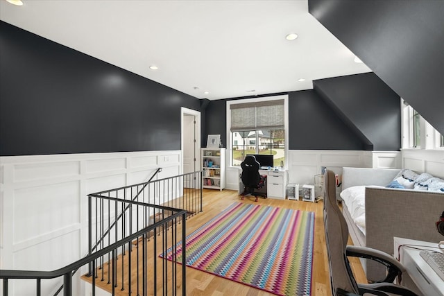 bedroom featuring light wood finished floors, recessed lighting, and wainscoting