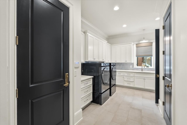 washroom with recessed lighting, cabinet space, ornamental molding, a sink, and independent washer and dryer