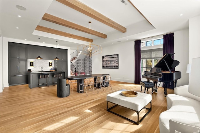 living room featuring recessed lighting, baseboards, stairs, light wood finished floors, and beamed ceiling