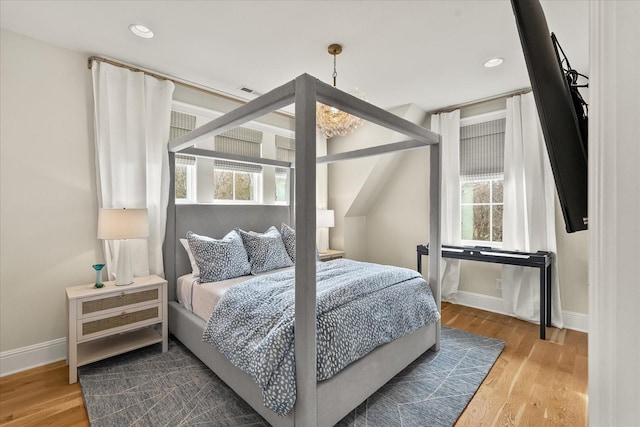 bedroom with baseboards, wood finished floors, and recessed lighting