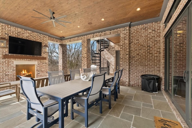 view of patio / terrace with an outdoor brick fireplace, outdoor dining area, stairway, and a ceiling fan