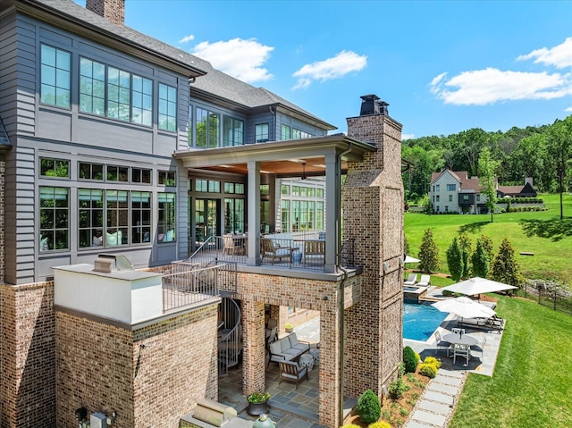 9289 Fordham Dr, Brentwood, TN 37027 - back of property with a patio, a chimney, a yard, an outdoor pool, and brick siding
