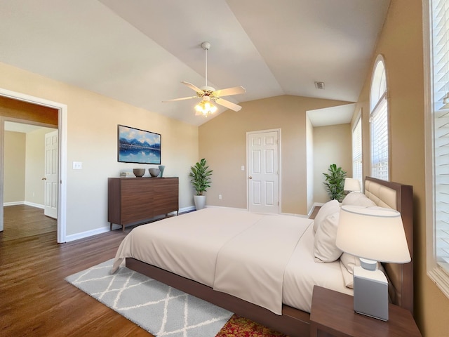 bedroom with visible vents, ceiling fan, vaulted ceiling, wood finished floors, and baseboards