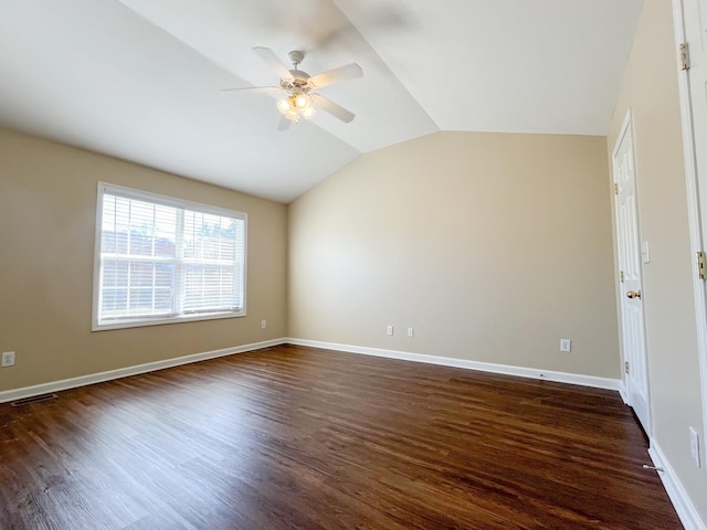 spare room with visible vents, baseboards, a ceiling fan, lofted ceiling, and dark wood-style flooring