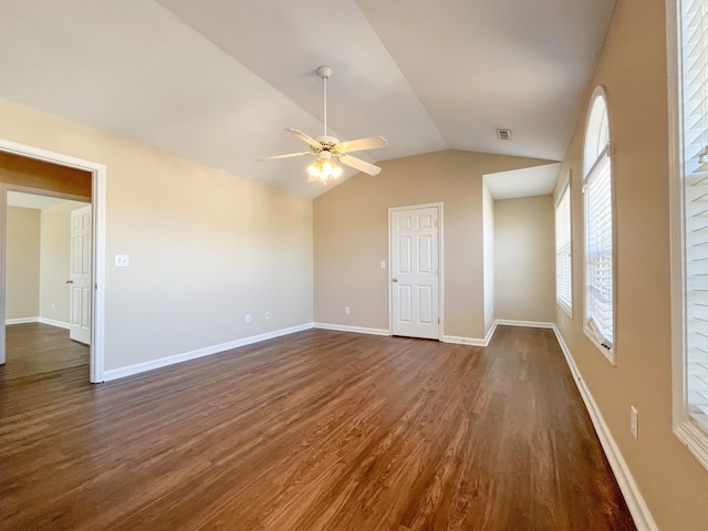 spare room with visible vents, baseboards, dark wood-style floors, ceiling fan, and vaulted ceiling