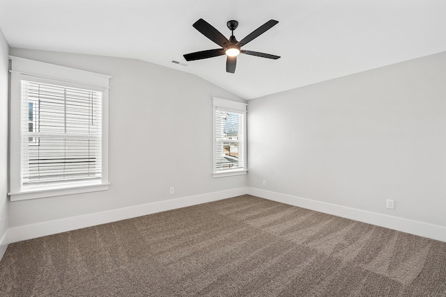 unfurnished room featuring baseboards, visible vents, a ceiling fan, vaulted ceiling, and dark carpet