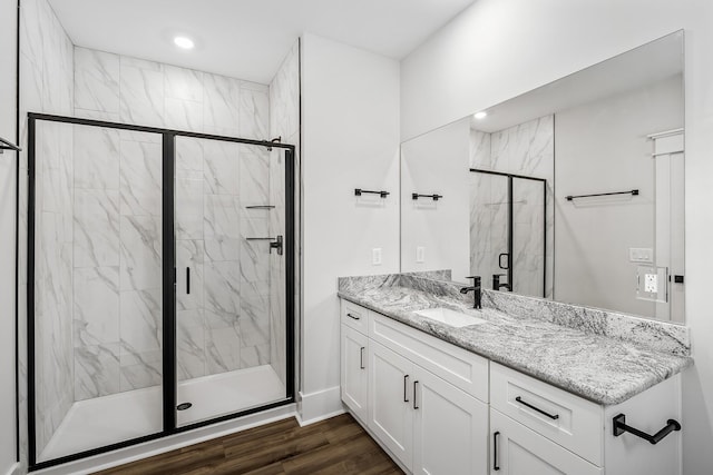 bathroom featuring recessed lighting, vanity, a marble finish shower, and wood finished floors